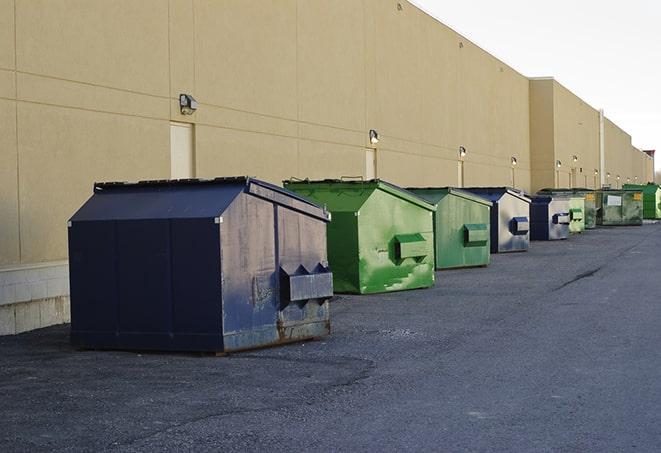 a stack of yellow construction dumpsters on a job site in Inwood